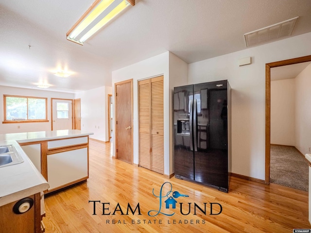 1235 S Durbin St, Casper, WY 82601 - kitchen featuring black refrigerator with ice dispenser, light countertops, light wood finished floors, and a sink