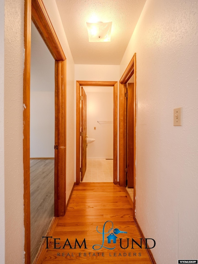 1235 S Durbin St, Casper, WY 82601 - hallway featuring light wood-style floors, a textured ceiling, and baseboards