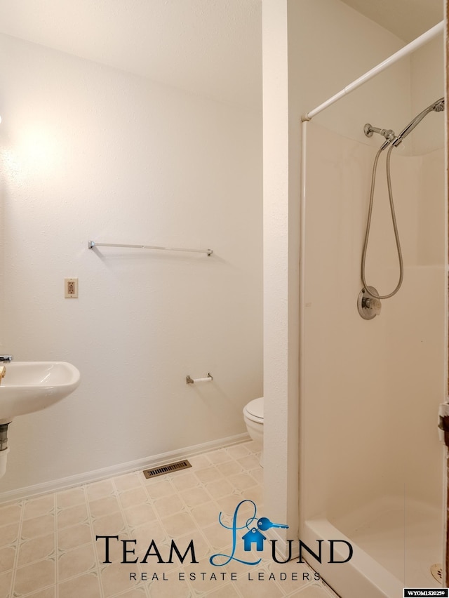 1235 S Durbin St, Casper, WY 82601 - bathroom with a shower stall, toilet, and baseboards