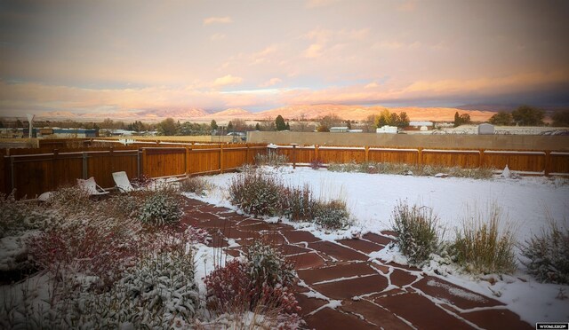 302 Clearview St, Saratoga, WY 82331 - yard covered in snow with a fenced backyard and a mountain view
