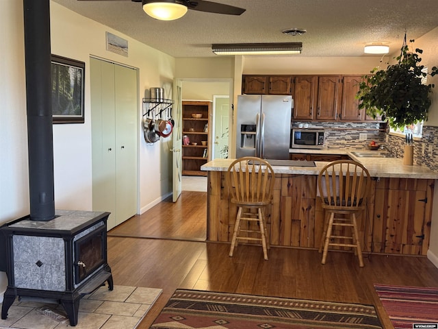 302 Clearview St, Saratoga, WY 82331 - kitchen featuring appliances with stainless steel finishes, a peninsula, wood finished floors, a sink, and backsplash