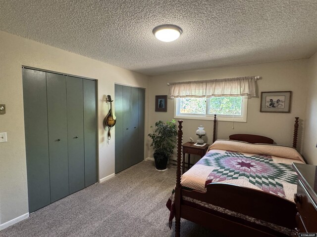 302 Clearview St, Saratoga, WY 82331 - carpeted bedroom with multiple closets, a textured ceiling, and baseboards