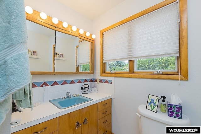 1823 Walnut St, Rock Springs, WY 82901 - bathroom with vanity, toilet, and decorative backsplash