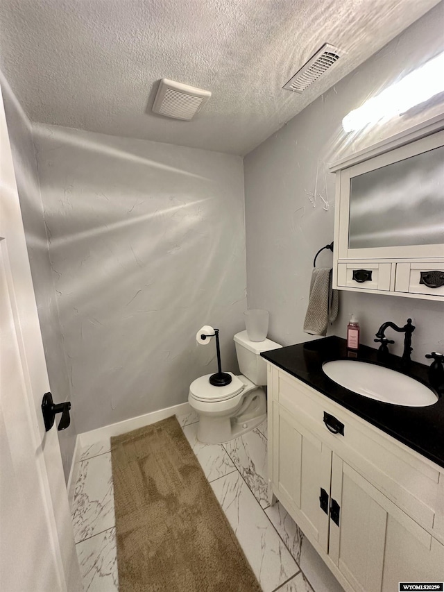 1023Pine Ave, Kemmerer, WY 83101 - bathroom featuring marble finish floors, toilet, vanity, and a textured ceiling