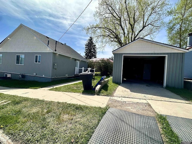 1023Pine Ave, Kemmerer, WY 83101 - view of side of home featuring concrete driveway, a detached garage, an outdoor structure, and a yard