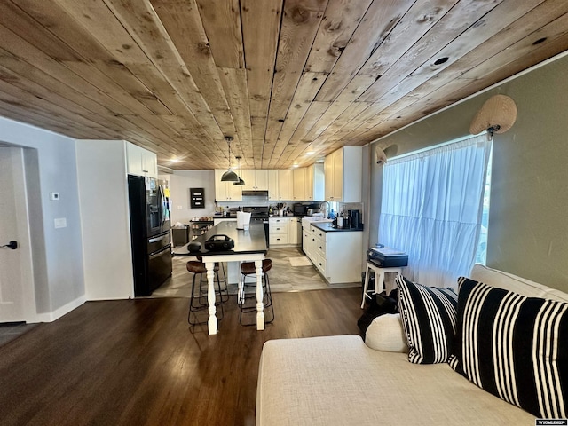 1023Pine Ave, Kemmerer, WY 83101 - kitchen featuring black fridge with ice dispenser, wood ceiling, dark wood-type flooring, white cabinets, and dark countertops