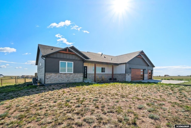 2352 Old Faithful Way, Cheyenne, WY 82009 - view of front of home with stone siding, a garage, central air condition unit, and driveway