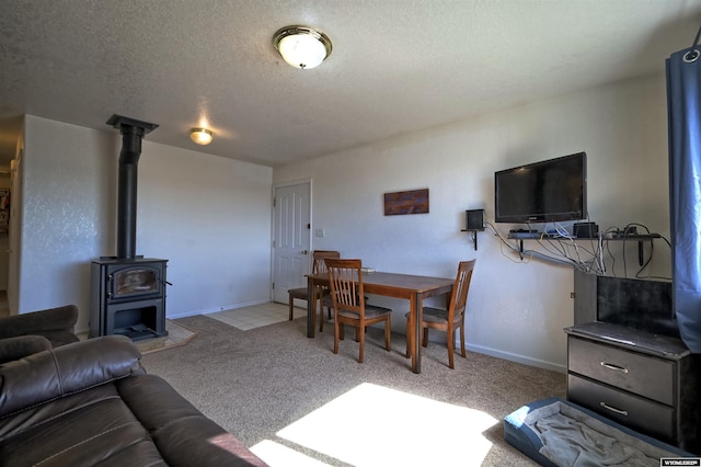 925 Skyline Dr, Douglas, WY 82633 - carpeted living area featuring a textured ceiling, a wood stove, and baseboards