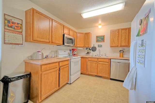 925 Skyline Dr, Douglas, WY 82633 - kitchen featuring stainless steel appliances, a sink, light countertops, light flooring, and a textured ceiling
