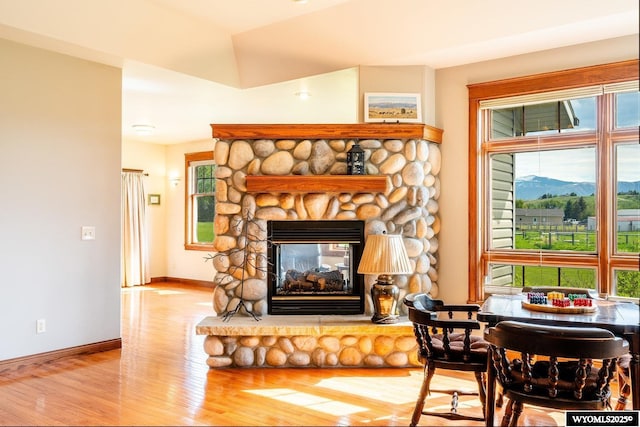 22 Pleasant Valley Ln, Sheridan, WY 82801 - living room featuring wood finished floors, a stone fireplace, baseboards, and a mountain view