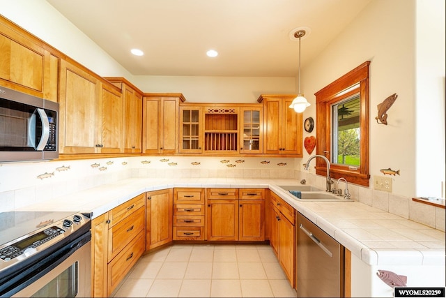 22 Pleasant Valley Ln, Sheridan, WY 82801 - kitchen featuring appliances with stainless steel finishes, a sink, pendant lighting, tile countertops, and glass insert cabinets