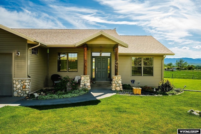 22 Pleasant Valley Ln, Sheridan, WY 82801 - view of front facade featuring an attached garage, a front yard, a mountain view, and roof with shingles