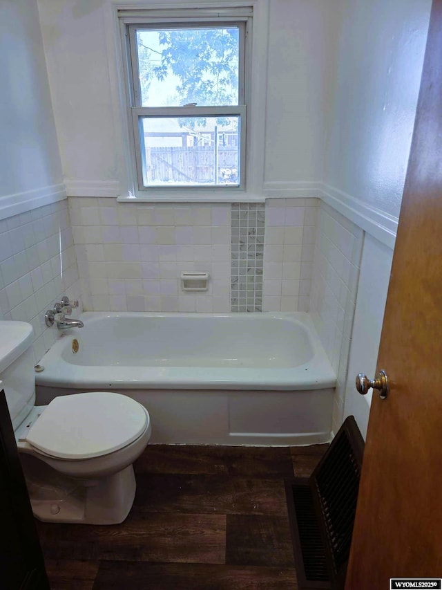 1308 Howell, Worland, WY 82401 - bathroom with toilet, a garden tub, wood finished floors, and a wainscoted wall