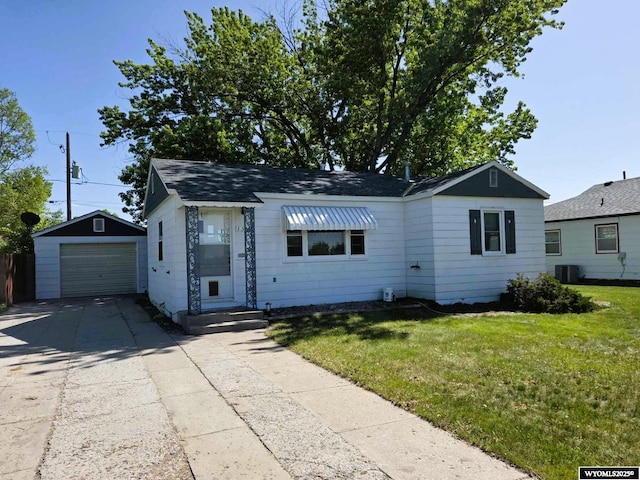 1308 Howell, Worland, WY 82401 - view of front of house featuring an outbuilding, driveway, a front lawn, a garage, and cooling unit