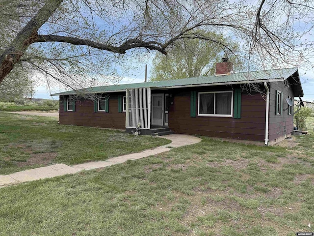 83 Calvert Ave, Hanna, WY 82327 - single story home featuring a chimney, metal roof, and a front lawn
