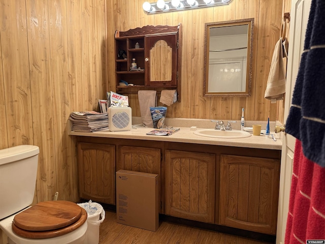 83 Calvert Ave, Hanna, WY 82327 - half bath featuring toilet, vanity, wooden walls, and wood finished floors