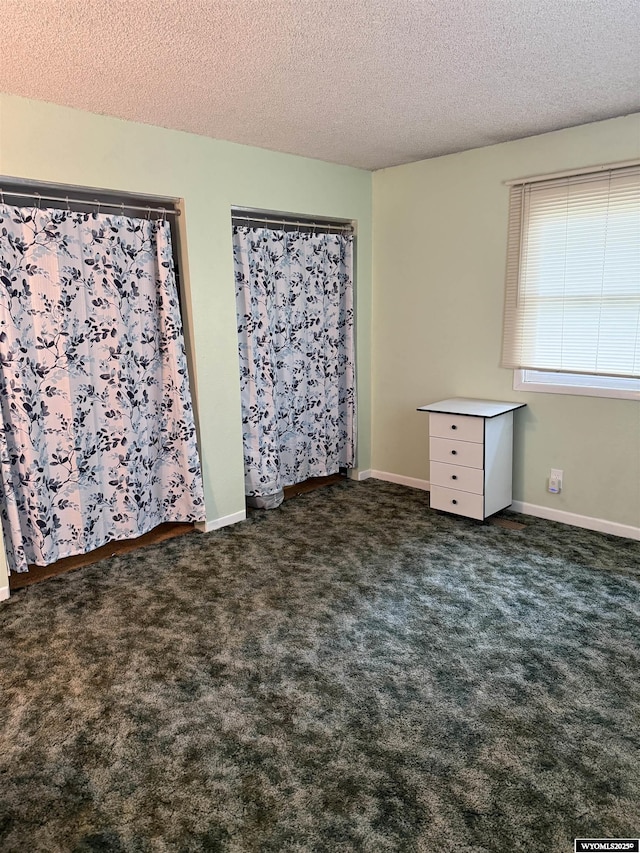 83 Calvert Ave, Hanna, WY 82327 - unfurnished bedroom featuring a textured ceiling and dark carpet