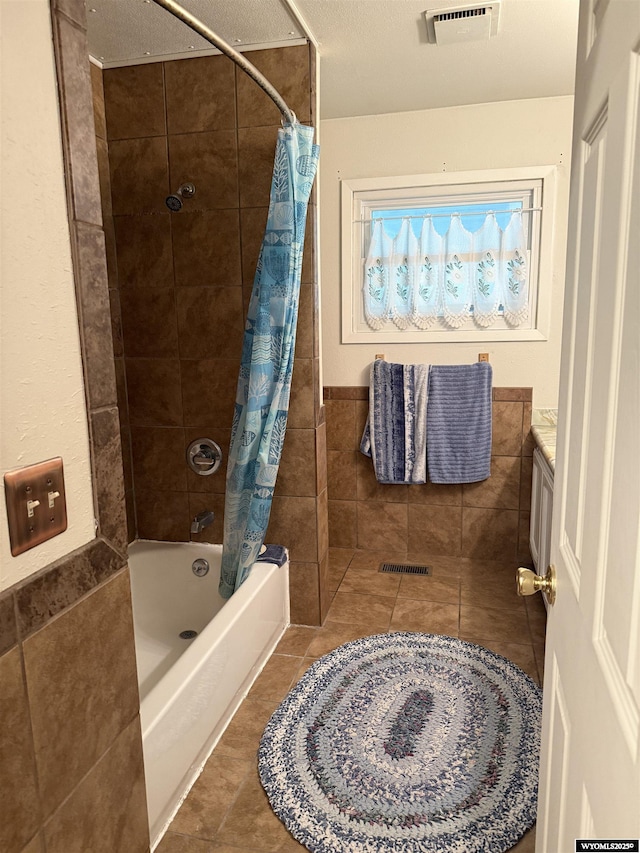 83 Calvert Ave, Hanna, WY 82327 - bathroom with tile patterned floors, vanity, shower / bathtub combination with curtain, and tile walls