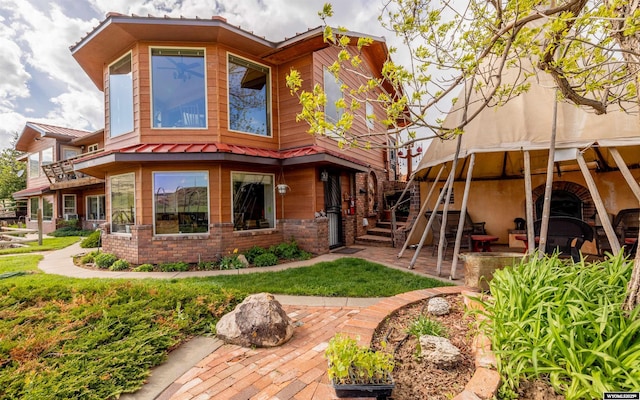 30 Nielsen Trl, Cody, WY 82414 - rear view of property with brick siding, a patio area, and metal roof