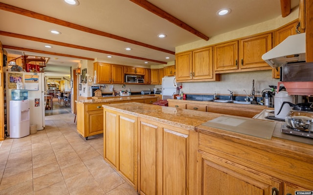 30 Nielsen Trl, Cody, WY 82414 - kitchen featuring stainless steel microwave, beam ceiling, under cabinet range hood, recessed lighting, and freestanding refrigerator