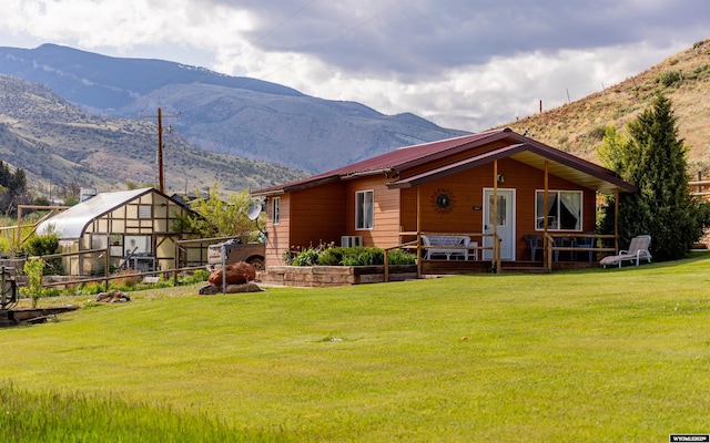 30 Nielsen Trl, Cody, WY 82414 - back of property featuring a mountain view, a lawn, an exterior structure, and an outdoor structure
