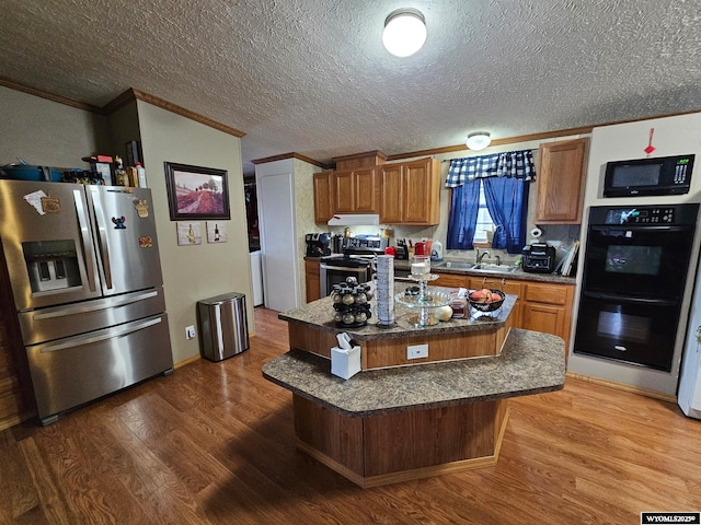 212 Vero Ln, Buffalo, WY 82834 - kitchen featuring black appliances, ornamental molding, wood finished floors, brown cabinets, and a sink