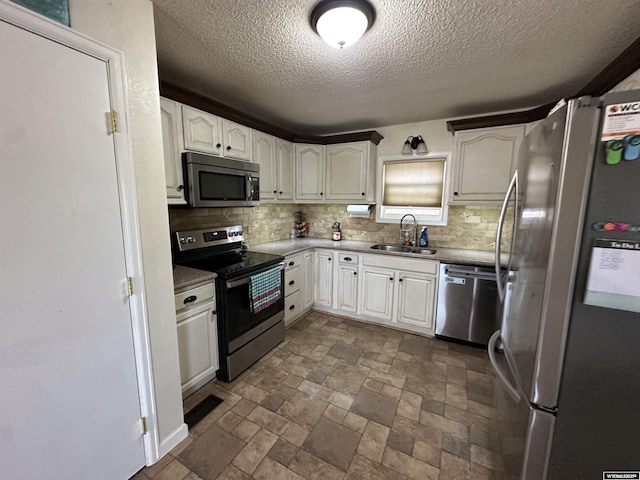 4 Meadowgreen Pl, Douglas, WY 82633 - kitchen with stainless steel appliances, a sink, tasteful backsplash, a textured ceiling, and white cabinets