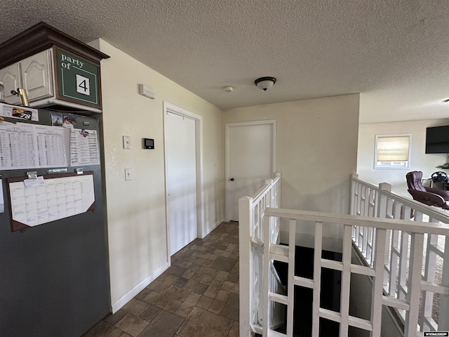 4 Meadowgreen Pl, Douglas, WY 82633 - hallway with baseboards, dark stone finish floors, an upstairs landing, and a textured ceiling
