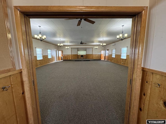 402 S 7th St E, Riverton, WY 82501 - spare room with a chandelier, ceiling fan, carpet flooring, wood walls, and wainscoting
