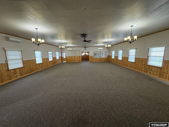 402 S 7th St E, Riverton, WY 82501 - spare room featuring a chandelier, wood walls, plenty of natural light, a wall mounted AC, and wainscoting