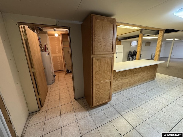 402 S 7th St E, Riverton, WY 82501 - kitchen featuring freestanding refrigerator, gas water heater, and light tile patterned floors