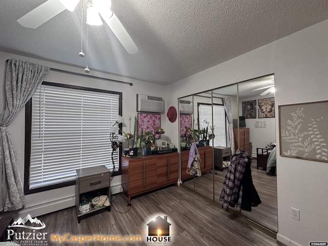 4500 S Poplar A St, Casper, WY 82604 - misc room featuring a ceiling fan, wood finished floors, a textured ceiling, a wall mounted air conditioner, and baseboard heating