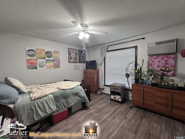 4500 S Poplar A St, Casper, WY 82604 - bedroom with a wall mounted air conditioner, wood finished floors, a textured ceiling, and ceiling fan