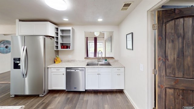 737 Cascade St, Lander, WY 82520 - kitchen featuring appliances with stainless steel finishes, a sink, open shelves, dark wood-style flooring, and white cabinetry
