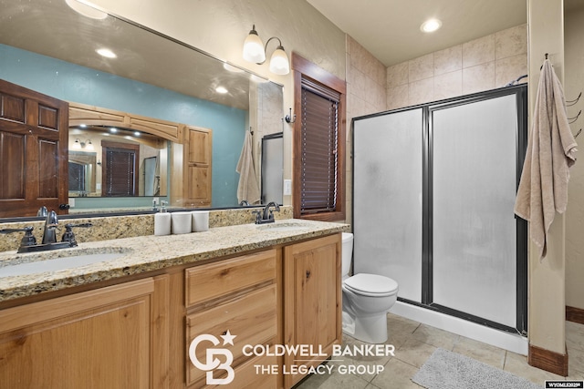 972 Cornwall St, Casper, WY 82609 - bathroom featuring toilet, a shower stall, double vanity, tile patterned floors, and recessed lighting