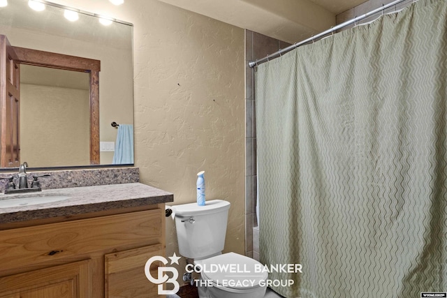 972 Cornwall St, Casper, WY 82609 - bathroom featuring a textured wall, vanity, toilet, and a shower with shower curtain