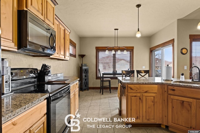 972 Cornwall St, Casper, WY 82609 - kitchen featuring black appliances, a sink, decorative light fixtures, light tile patterned floors, and brown cabinetry