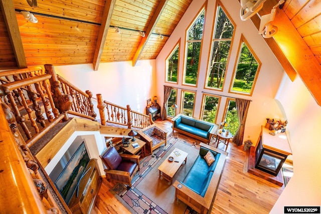 43 Fish Hatchery Rd, Story, WY 82842 - living area featuring wood ceiling with exposed beams, high vaulted ceiling, wood-type flooring, a fireplace, and stairway