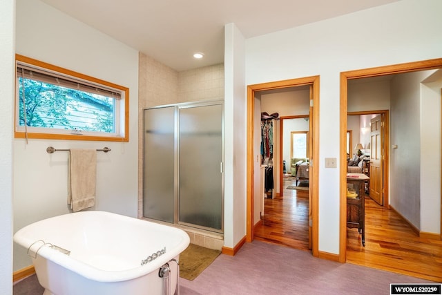 43 Fish Hatchery Rd, Story, WY 82842 - full bathroom featuring a shower stall, a freestanding tub, a walk in closet, baseboards, and wood finished floors