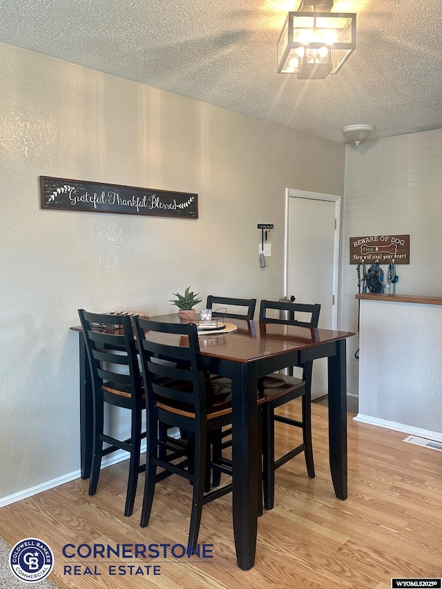 3024 Hamilton Way, Casper, WY 82609 - dining room featuring wood finished floors, a textured ceiling, and baseboards