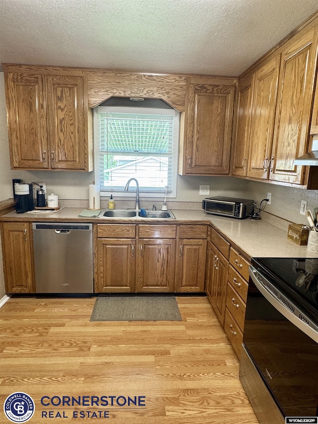 3024 Hamilton Way, Casper, WY 82609 - kitchen featuring stainless steel appliances, a sink, ventilation hood, light wood-type flooring, and a textured ceiling