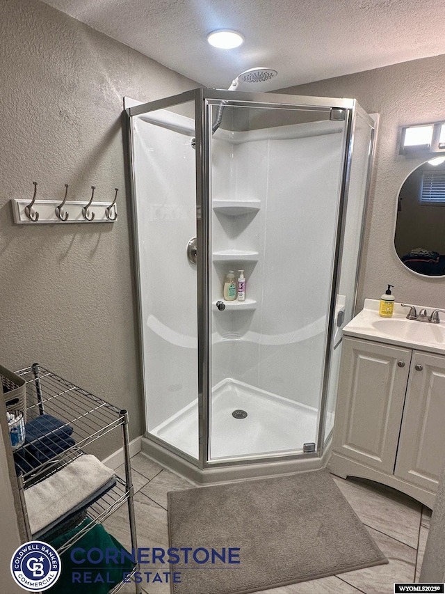 3024 Hamilton Way, Casper, WY 82609 - bathroom featuring a textured wall, a textured ceiling, a stall shower, vanity, and tile patterned floors