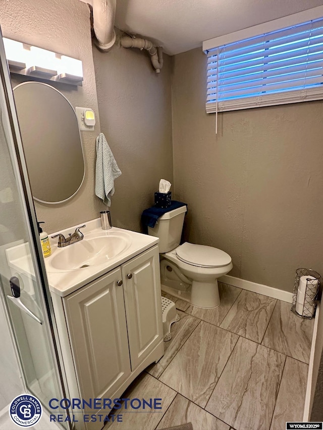 3024 Hamilton Way, Casper, WY 82609 - bathroom featuring vanity, toilet, marble look tiles, and baseboards