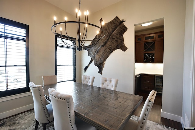 3685 Timber Wolf Ct, Casper, WY 82604 - dining room featuring wine cooler, a chandelier, baseboards, and dark wood-style flooring