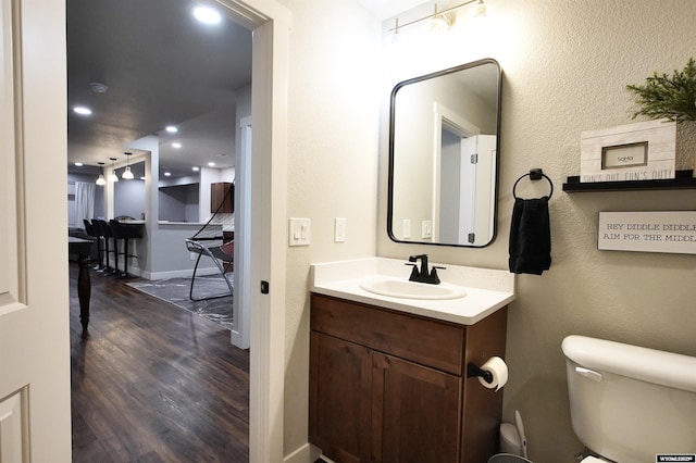 3685 Timber Wolf Ct, Casper, WY 82604 - bathroom featuring vanity, wood finished floors, toilet, recessed lighting, and baseboards