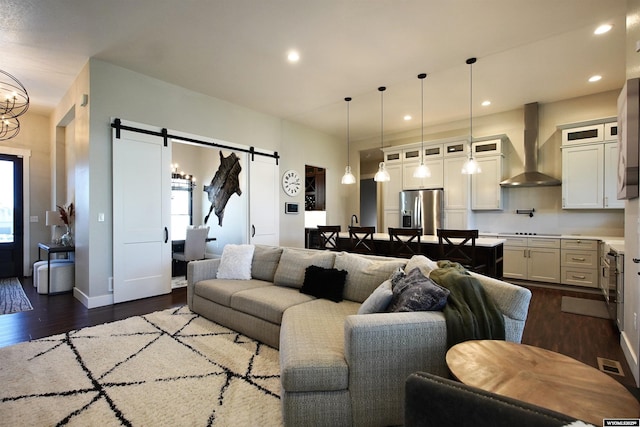 3685 Timber Wolf Ct, Casper, WY 82604 - living room with a barn door, dark wood finished floors, recessed lighting, and baseboards