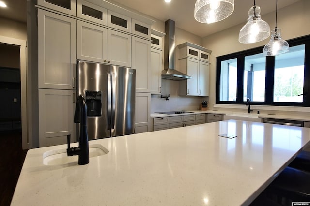 3685 Timber Wolf Ct, Casper, WY 82604 - kitchen featuring wall chimney exhaust hood, stainless steel fridge with ice dispenser, black electric stovetop, decorative light fixtures, and a breakfast bar