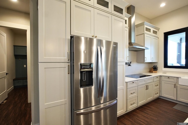 3685 Timber Wolf Ct, Casper, WY 82604 - kitchen featuring stainless steel fridge, wall chimney exhaust hood, dark wood-type flooring, light countertops, and glass insert cabinets
