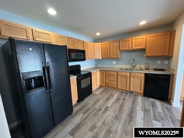517 Archers Trl, Rock Springs, WY 82901 - kitchen with black appliances, a sink, light brown cabinets, light countertops, and a textured ceiling