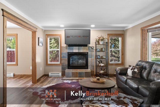 5411 S Oak St, Casper, WY 82601 - living room with baseboard heating, wood finished floors, a baseboard radiator, a tiled fireplace, and baseboards
